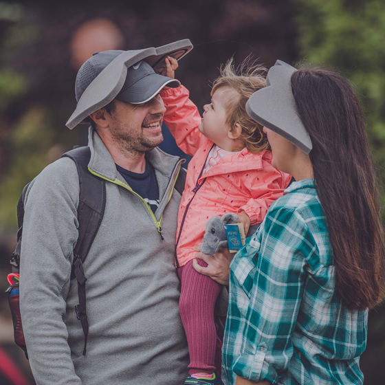 Parents Holding Their Young Daughter Wearing Elephant Ears