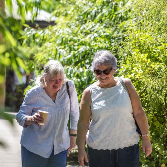 Two Older Ladies Laughing As They Walk Through The Zoo